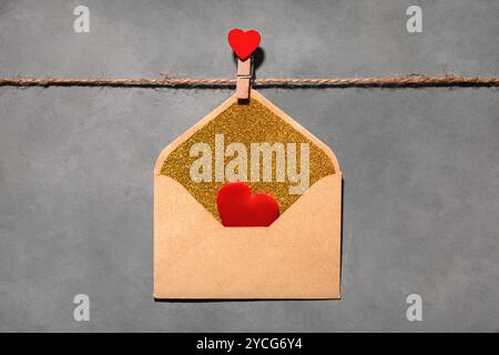 clothespin with red heart on a rope on a gray background. an envelope with a red heart inside. symbol of love, passion. flat lay, top view, Love, Vale Stock Photo
