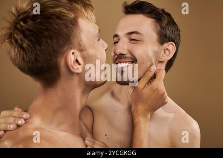 Two young men share a joyful embrace, expressing love and intimacy in a cozy atmosphere. Stock Photo