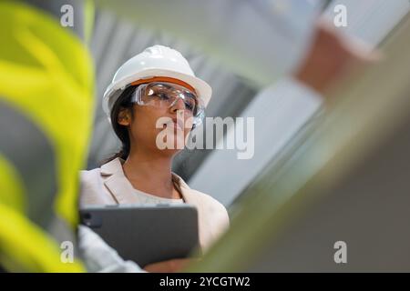 Young Indian woman, a successful production manager using a tablet during factory inspection. Manufacturing and business concepts. Stock Photo