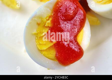 Boiled egg with ketchup and salt. Stock Photo