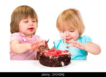 Two little baby girl eating cake Stock Photo