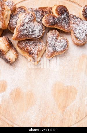 Bakery hearts from split pastry with sugar powder on wooden Stock Photo