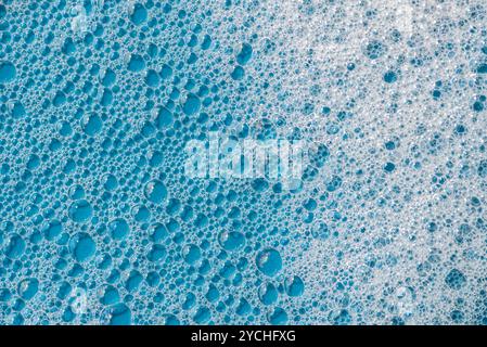 Background and pattern. White soap foam with bubbles, texture on blue tile background. Detergent foam bubble on tile. shower gel, hair shampoo foam sm Stock Photo