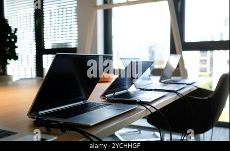 Laptops on a table in an empty co-working space Stock Photo