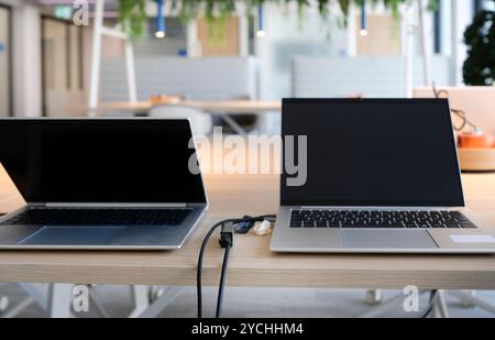 Laptops on a table in an empty co-working space Stock Photo