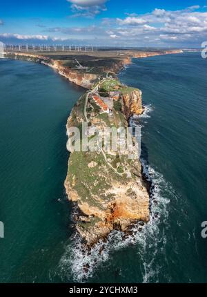 Aerial view of a lighthouse on a rocky cliff overlooking the ocean ...