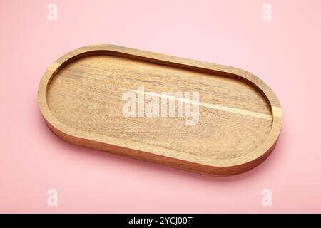 Empty wooden tray on pink background. Rectangular wooden dish. Top view Stock Photo