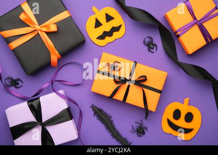 Halloween flat lay with orange, black and purple seasonal paper craft gift boxes on violet background. Top view Stock Photo