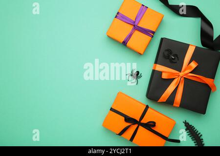 Happy Halloween holiday concept. Flat lay gift boxes with spiders on mint background. Halloween greeting card template. Top view Stock Photo