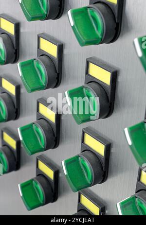 A lot of green electric switches with yellow labels on a brushed metal ...