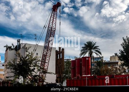 A large crane hoists stone crushing equipment on a construction site in Ibiza, Spain. Stock Photo