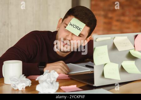Overworked man sleeping tired of office multitasking work indoor Stock Photo