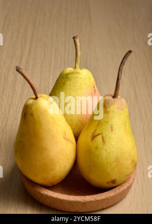 Three pears on centerpiece cork tray studio shot still life nature morte Stock Photo