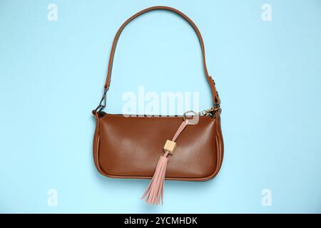 Bag with pink leather keychain on light blue background, top view Stock Photo