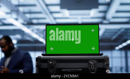Green screen laptop used by engineers monitoring server room, doing checkup. Focus on chroma key notebook used by IT support employee working in data center facility, camera A close up Stock Photo