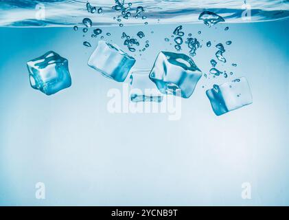Ice cubes falling under water Stock Photo