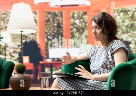 Psychotherapist listening to client at counseling session and taking notes, discussing about social anxiety and mental health issues. Expert doing a psychoanalysis during therapy. Stock Photo