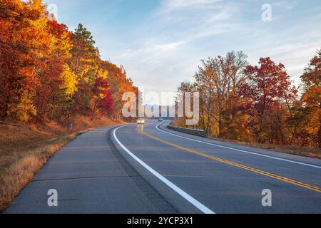 Cars travel along a curve in the road near the Mississippi River in Brainerd Minnesota on an autumn morning Stock Photo