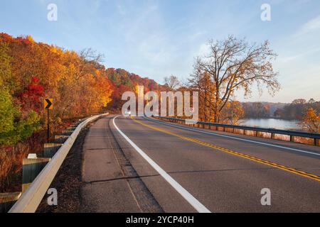 Curve in the road along the Mississippi River and Rice Lake near Brainerd Minnesota on an autumn morning Stock Photo