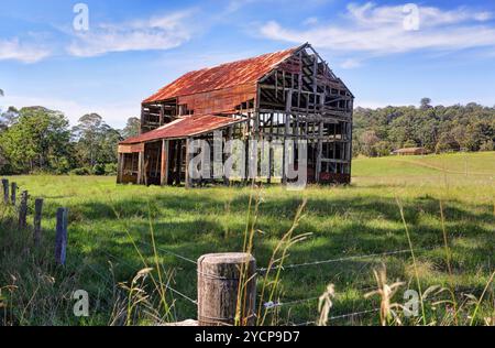 This old ramshackle rustic glory a once grand two storey barn with corrugated roof and timber trusses now just a skeleton of what it formerly was, its Stock Photo