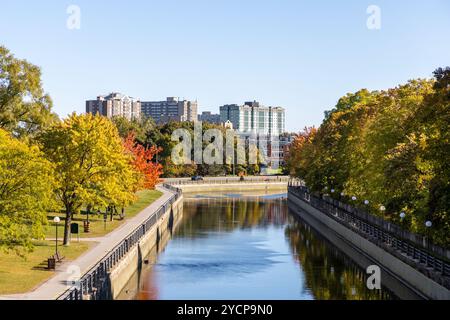 Rideau Canal in Ottawa, Canada during the autumn season lined with fall trees and residential buildings in background. Stock Photo