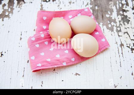 Eggs on tablecloth over wooden background Stock Photo