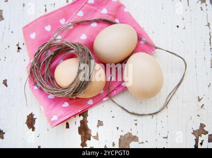 Eggs on tablecloth over wooden background Stock Photo