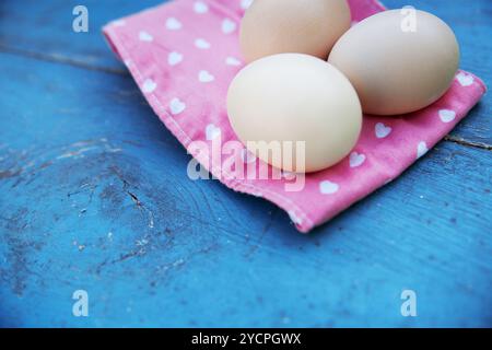 Eggs on tablecloth over wooden background Stock Photo