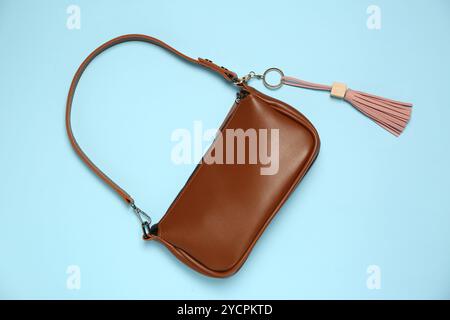 Bag with pink leather keychain on light blue background, top view Stock Photo