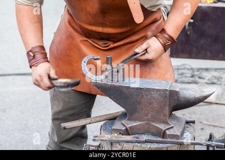 Blacksmith handles the horseshoe on the anvil Stock Photo
