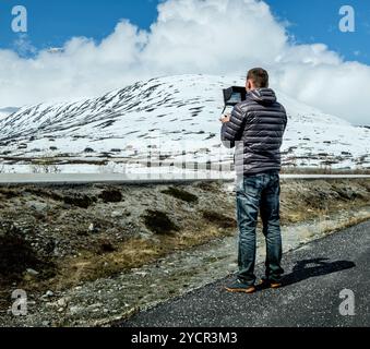 Pilot controls the drone performing flight over the mountains Stock Photo