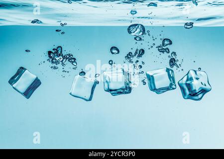 Ice cubes falling under water Stock Photo