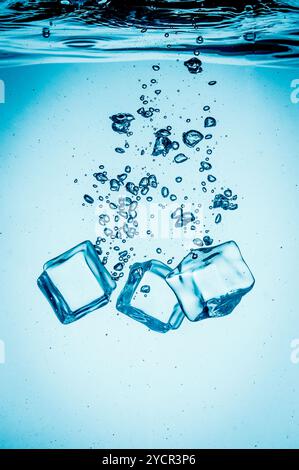 Ice cubes falling under water Stock Photo