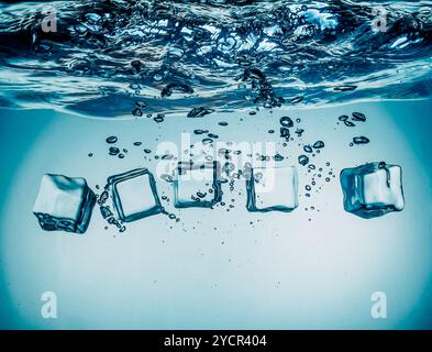 Ice cubes falling under water Stock Photo