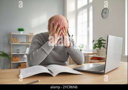 Elderly Man Working With A Laptop In A Home Office Suffering From Headache Stock Photo