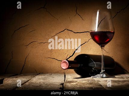 Wine and cracked clay wall in cellar Stock Photo