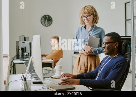 IT Specialists Smiling While Looking At Computer Screen Stock Photo