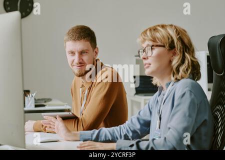 Young Man and Woman Working on Computer in IT Office Stock Photo