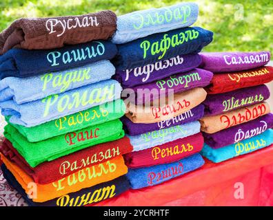 Stack of the multicolored towels with embroidered Tatar names Stock Photo