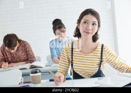 Female university students taking classes Stock Photo