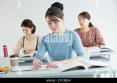 Female university students taking classes Stock Photo