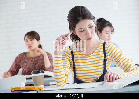 Female university students taking classes Stock Photo