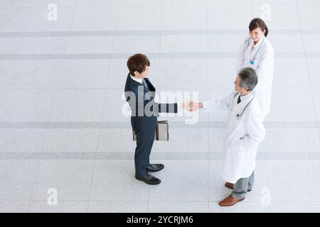 Businessman and doctor shaking hands Stock Photo