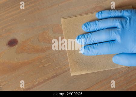 Person sanding wood board using coarse 80 grit grained sandpaper. Do it yourself carpentry concept. Stock Photo