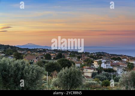 A view of the village of Ricadi in Calabria at sunrise with Sicily and Mount Etna in the background Stock Photo