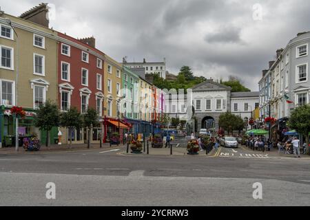 Cobh, Ireland, 15 August, 2022: town square in Cobh with colorful houses and the Lusitania Memorial statue, Europe Stock Photo