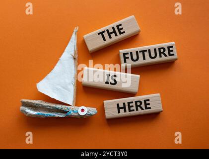 The future is here symbol. Concept words The future is here on wooden blocks. Beautiful orange background with boat. Business and The future is here c Stock Photo