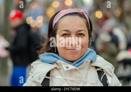 Beautiful woman of oriental appearance 40 - 45 years old on the background of blurred urban landscape. Stock Photo