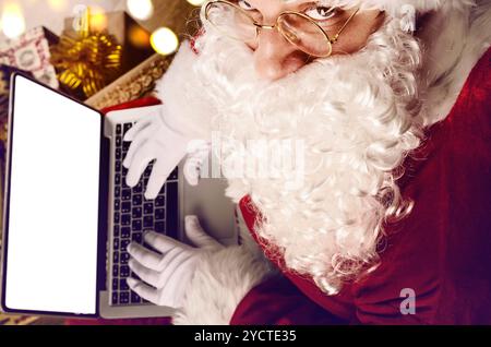 Santa Claus working on modern laptop Stock Photo