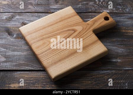 Empty wooden cutting board on wooden background, mockup for creative design. Stock Photo